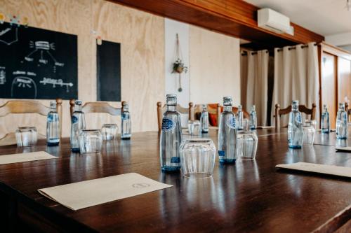a long wooden table with bottles and glasses on it at Logis Hôtel Restaurant Espelletenia in Larceveau-Arros-Cibits