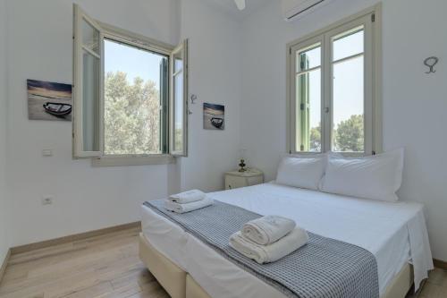 1 dormitorio blanco con 2 toallas en una cama en Ouzo Traditional House with private pool, en Plomari