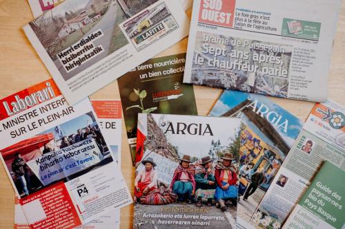 a table topped with lots of magazines and newspapers at Logis Hôtel Restaurant Espelletenia in Larceveau-Arros-Cibits