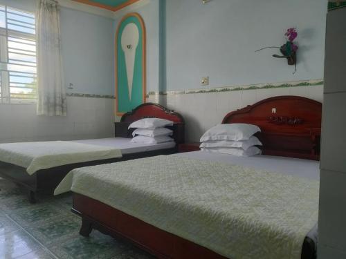 two beds in a hotel room with two beds at Ngoc Mai 1 Hotel in Can Tho