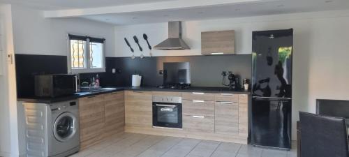 une cuisine avec une machine à laver et un lave-vaisselle dans l'établissement aux creissauds, à Aubagne