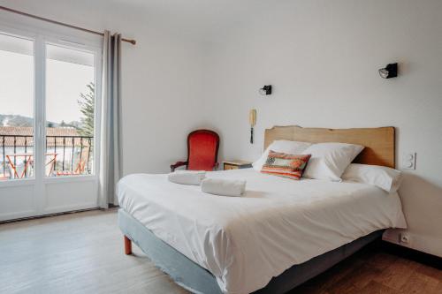 a bedroom with a large bed and a large window at Logis Hôtel Restaurant Espelletenia in Larceveau-Arros-Cibits