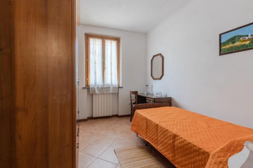 a bedroom with a bed and a desk and a window at Casa Vacanza Rocchetti with Parking&Garden! in Porcari