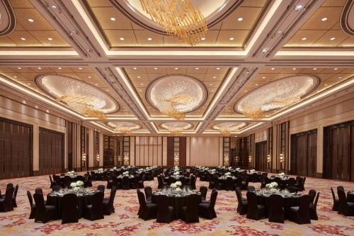 a large ballroom with tables and chairs and chandeliers at Kerry Hotel Pudong, Shanghai - Indoor Connecting to Shanghai New International Expo Centre in Shanghai