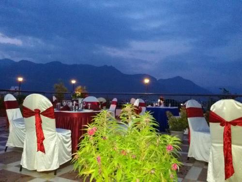 a group of tables with red and white bows at Hotel Western Gatz in Theni