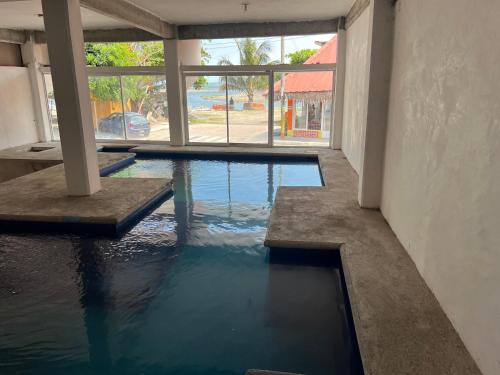 ein Schwimmbad in einem Gebäude mit Wasser darin in der Unterkunft Hotel MARU Pool & Events in Chachalacas
