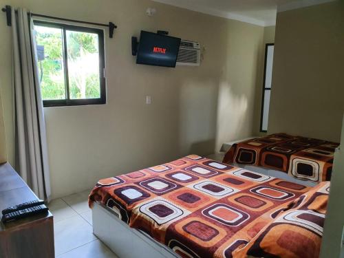 Hotel MARU Pool & Events في شاشالاكاس: غرفة نوم بسريرين وتلفزيون على الحائط