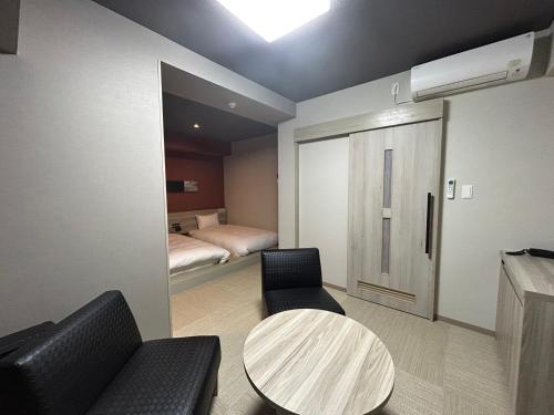 a room with a table and chairs and a bed at Hotel Route Inn Grand Chichibu in Chichibu