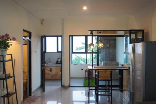 Una cocina con refrigerador y una mesa con sillas. en Cozy Haven with Jacuzzi, Rooftop, en Bandung