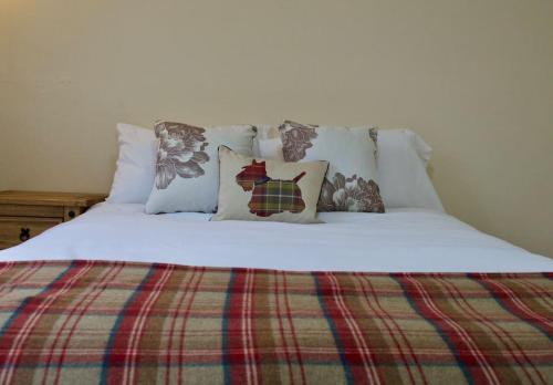 - un lit avec des draps et des oreillers blancs dans l'établissement Caledonian - Charming Central 1 Bed Flat, à Édimbourg