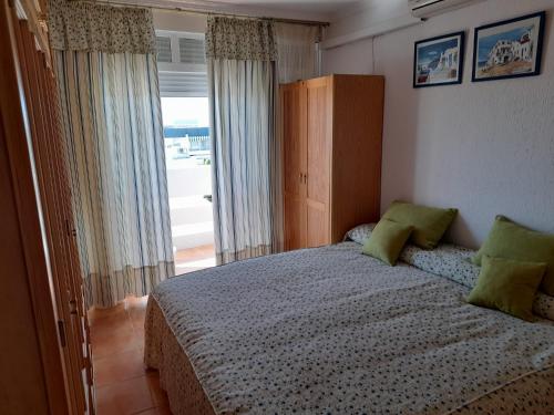 1 dormitorio con cama y ventana grande en Apartamento 335 Hotel Flamero en Matalascañas