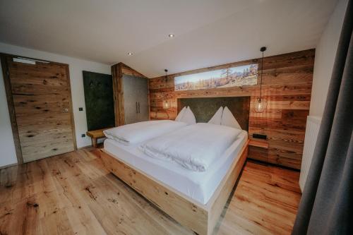 a bedroom with a large bed in a room with wooden walls at Frühstückspension Friedheim in Filzmoos