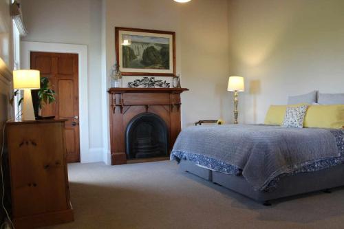 a bedroom with a bed and a fire place at The Suite - Huntly House in Auckland