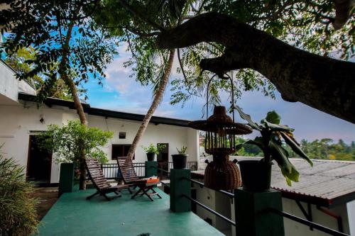 a porch of a house with chairs and a tree at Villa tadini in Galle