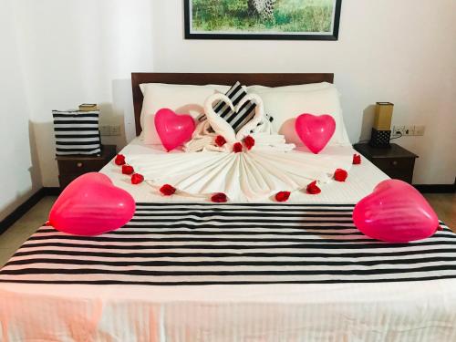 a bed with red heart decorations on top of it at Villa tadini in Galle