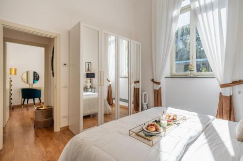 um quarto branco com uma bandeja de frutas numa cama em Maison Mirò with private parking em Lucca