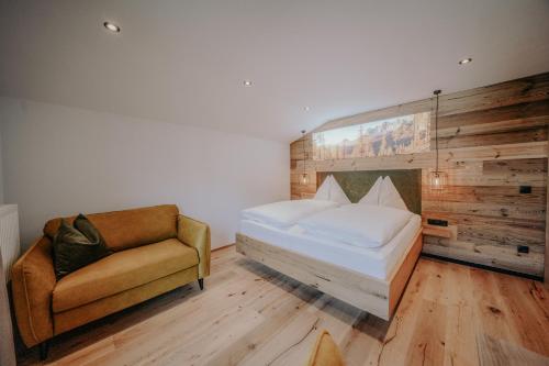 ein Schlafzimmer mit einem Bett und einem Stuhl in der Unterkunft Frühstückspension Friedheim in Filzmoos