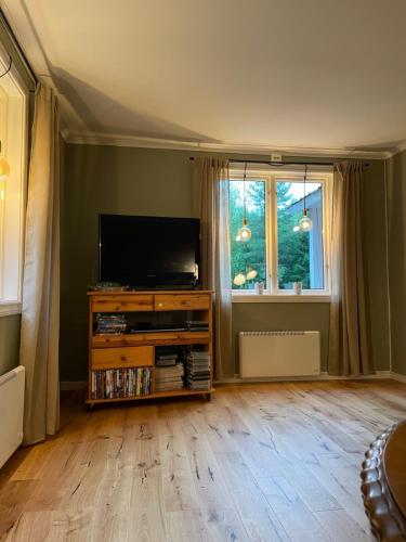 a living room with a flat screen tv and a window at Torp ved Mårbacka (Helt hus til leie) Östra Ämtervik/ Sunne in Östra Ämtervik