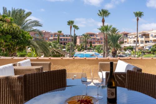 a table with a bottle of wine and glasses on the beach at Tropical Paradise in Harbour Paphos, Central & Close to Beach in Paphos City