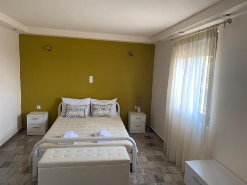 1 dormitorio con 2 camas y pared verde en Eucalyptοs house, en Lefkogeia