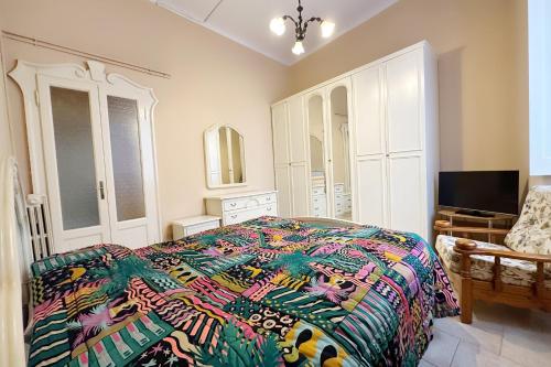 1 dormitorio con 1 cama con un edredón colorido en Casina modesta, en Somma Lombardo