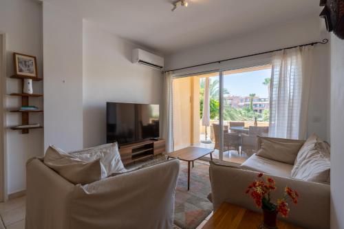 a living room with two couches and a television at Tropical Paradise in Harbour Paphos, Central & Close to Beach in Paphos