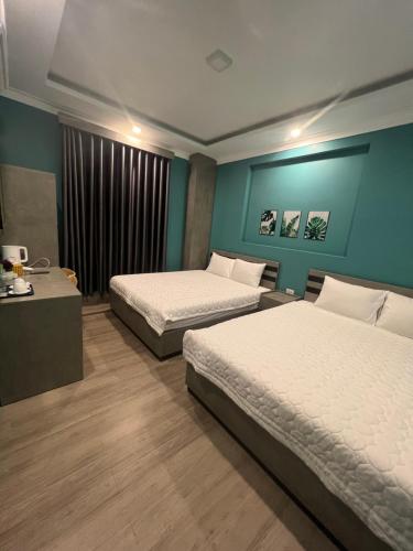 2 Betten in einem Zimmer mit blauen Wänden in der Unterkunft BALI HOTEL in Ấp An Bình