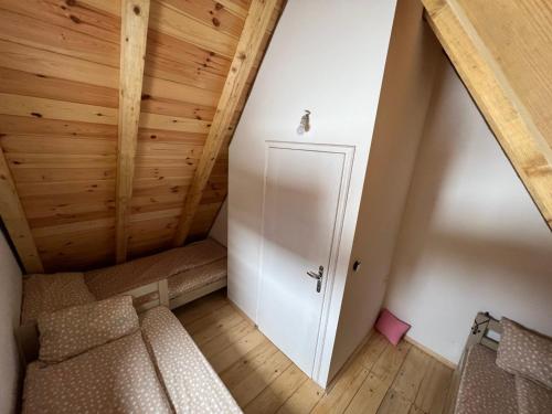 an attic room with a couch and a door at Žabljak- FamilyOasis in Žabljak