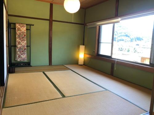 an empty room with a large window and a light at 吉野長屋 in Yoshino