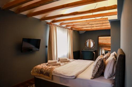 a bedroom with a large bed with a wooden ceiling at Adess Otel in Çekme