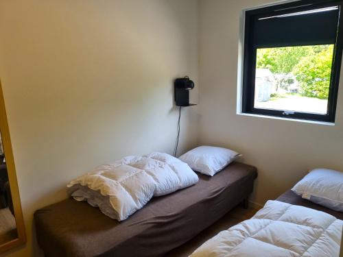 a room with two beds and a window at Randers City Camp in Randers