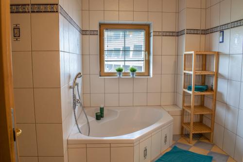 a bathroom with a tub and a window at Weinzeit Chalet & Appartements in Königsleiten