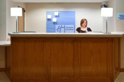 a woman is standing behind a reception desk at Holiday Inn Express Murrysville - Delmont by IHG in Delmont