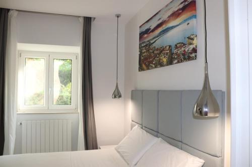 Un dormitorio con una cama y un cuadro en la pared. en Raila House, en Piano di Sorrento