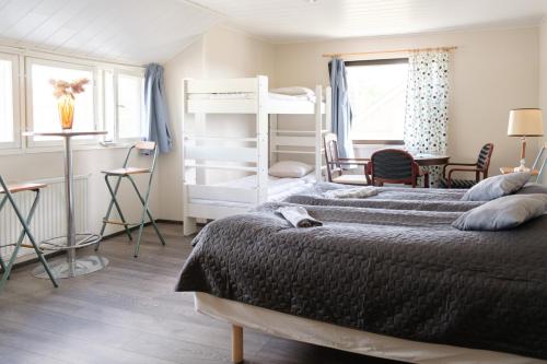a bedroom with two bunk beds and a desk at Bed & Breakfast Restaurang Sybarit in Houtskari