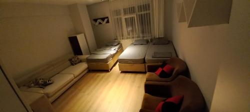 een kamer met drie bedden en een bank erin bij evim pansiyon konaklama in Bostancılı