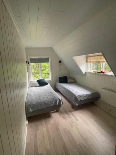 a attic bedroom with two beds and a window at Torp ved Mårbacka (Helt hus til leie) Östra Ämtervik/ Sunne in Östra Ämtervik