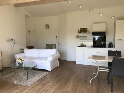 uma sala de estar com um sofá branco e uma mesa em Hameau de Chantelierre em Éguilles