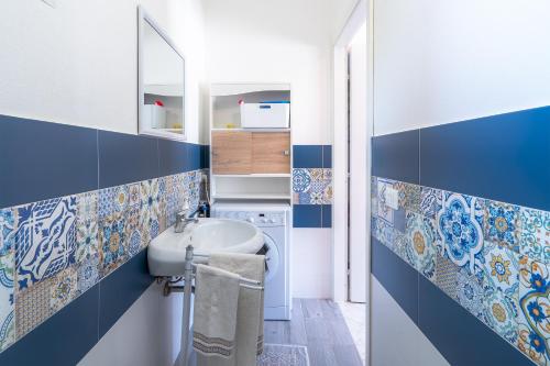 Baño con azulejos azules y blancos en la pared en Mini appartamento in Villa, en Noto