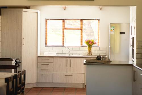 a kitchen with a vase of flowers on the counter at Villa Wal Farmstay in Hartebeest Rivier