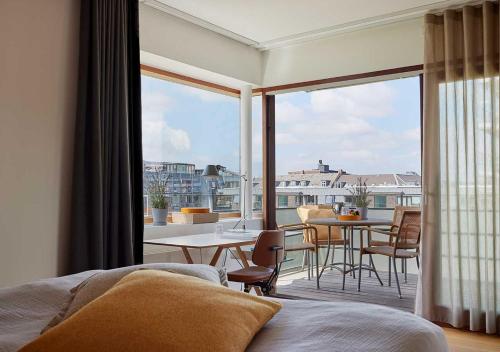 a bedroom with a balcony with a table and chairs at Charlottehaven in Copenhagen
