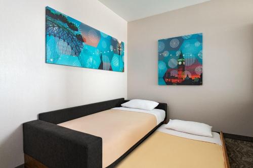 two beds in a room with paintings on the wall at Springhill Suites by Marriott Anaheim Maingate in Anaheim