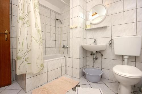 a bathroom with a toilet and a sink and a mirror at Apartments and rooms by the sea Pag - 3152 in Pag