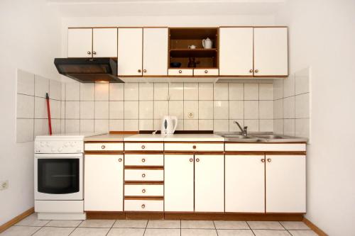 a kitchen with white cabinets and a sink at Apartments and rooms by the sea Pag - 3152 in Pag