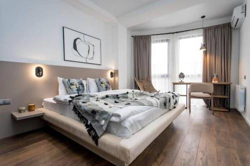 Habitación grande de color blanco con cama grande y escritorio. en New & Stylish 1 bedroom apartment near Fabrika, en Tiflis