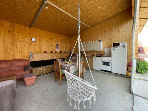 um quarto com uma cozinha e um baloiço numa casa em Petlov Konak em Mala Remeta
