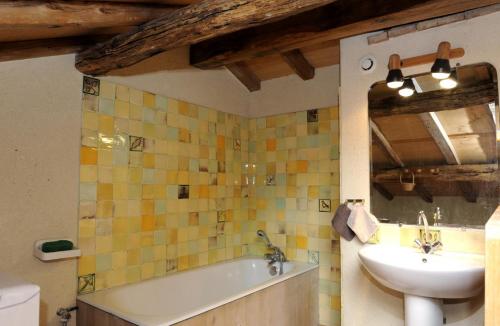 La salle de bains est pourvue d'un lavabo et d'une baignoire à côté d'un lavabo. dans l'établissement Les tavillons, à Soulaines-Dhuys
