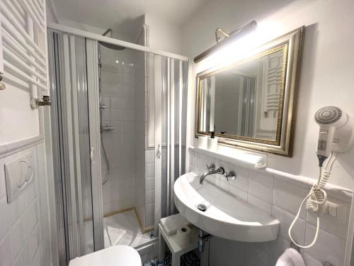 a white bathroom with a sink and a shower at INTERNO ROMA in Rome