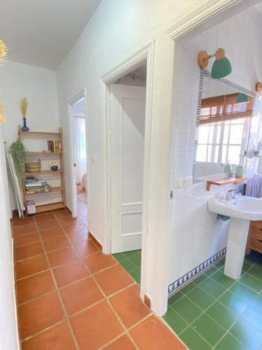een badkamer met een witte wastafel en een groene vloer bij Tierra del Sur in Conil de la Frontera
