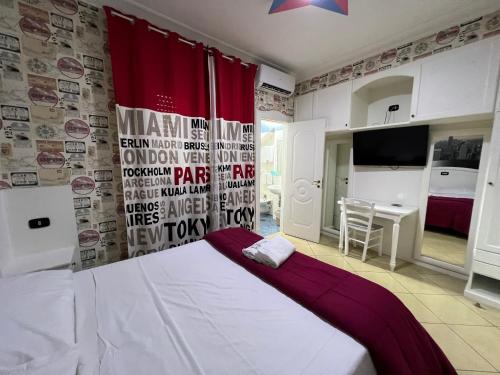 a bedroom with a bed and a red curtain at Hotel Tiffany in Varcaturo